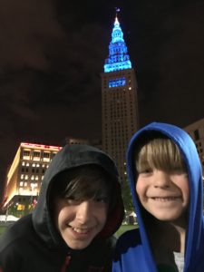 Two Kids in front of the Teal lit Terminal Tower
